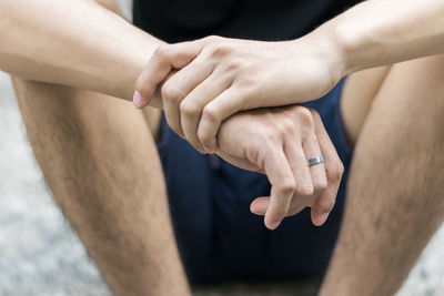 Midsection of man sitting outdoors