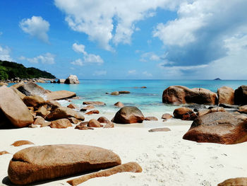 Rocks on beach against sky