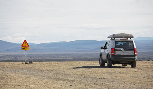 Suv stopped in front of traffic sign in the highlands of iceland