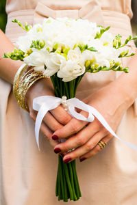 Midsection of woman holding flower bouquet