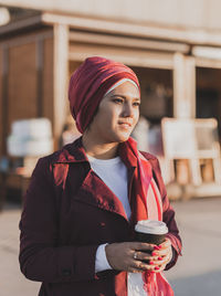 Portrait of young woman holding food