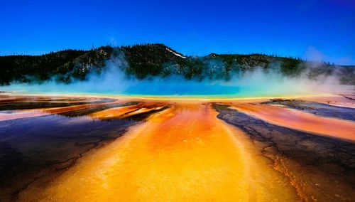 Idyllic shot of hot spring and smoke at yellowstone national park against sky