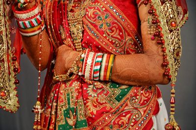 Midsection of bride wearing sari at home 