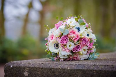 Close-up of bouquet on retaining wall outdoors