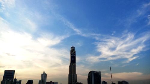 Low angle view of skyscrapers against cloudy sky