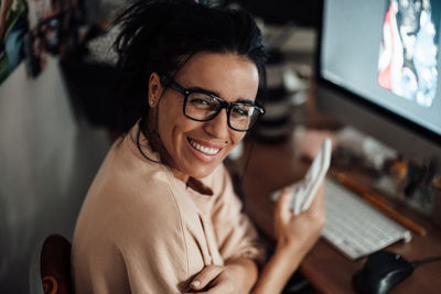 Portrait of smiling woman using mobile phone