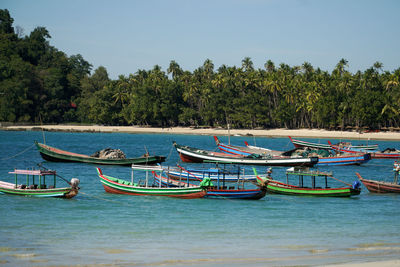 Colorful boats lying in bay of ngapali against sky