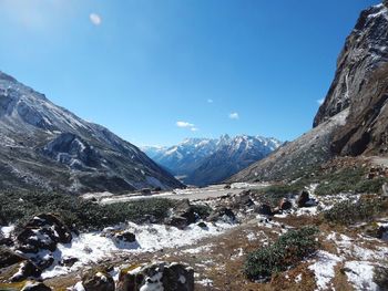 Scenic view of snowcapped mountains against blue sky