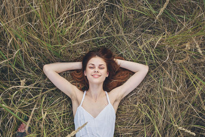 Portrait of young woman lying on field