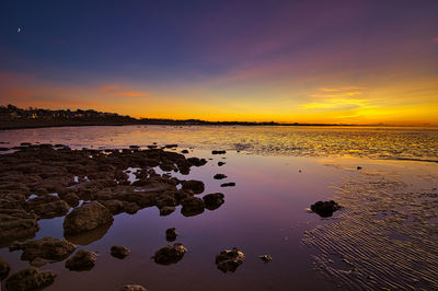 Scenic view of sea against romantic sky at sunset