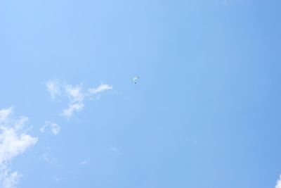 Low angle view of paragliding against clear blue sky