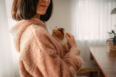 Midsection of woman holding toy at home