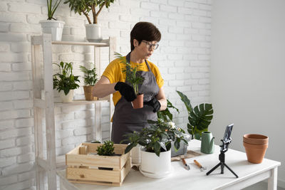 Young woman holding potted plant