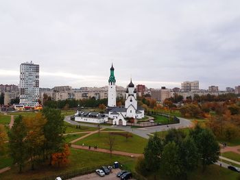 View of buildings in city against cloudy sky