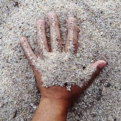 Close-up of hand on sand