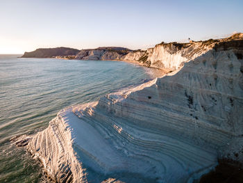 Scenic view of sea and mountains against clear sky