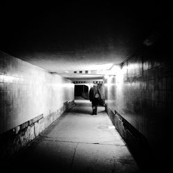 Rear view of woman walking in tunnel