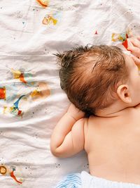 High angle view of shirtless boy sleeping on bed at home