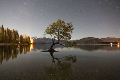 Scenic view of lake against clear sky at night