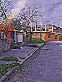 Street amidst houses and buildings against sky