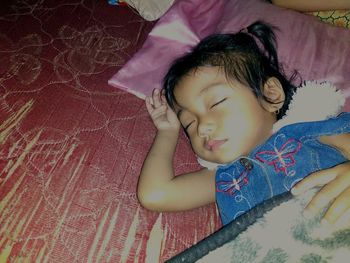 High angle view of girl sleeping on bed