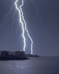 Lightning over sea against clear sky during night