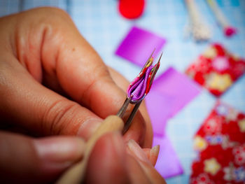 Cropped hands making fabric artwork at table