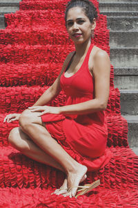 Portrait of a woman sitting on the red stairs. 