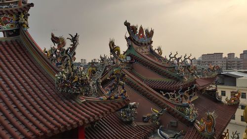 Statues on roof of building against sky