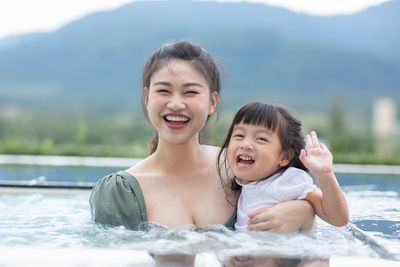 Portrait of happy mother and daughter in water