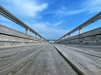 Surface level of footbridge against sky