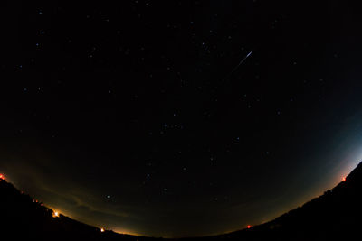 Low angle view of silhouette mountain against sky at night