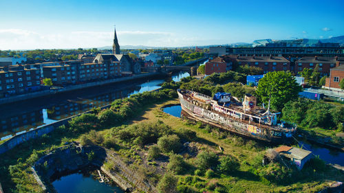 High angle view of river amidst buildings in city against sky