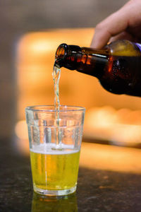 Close-up of hand pouring drink in glass