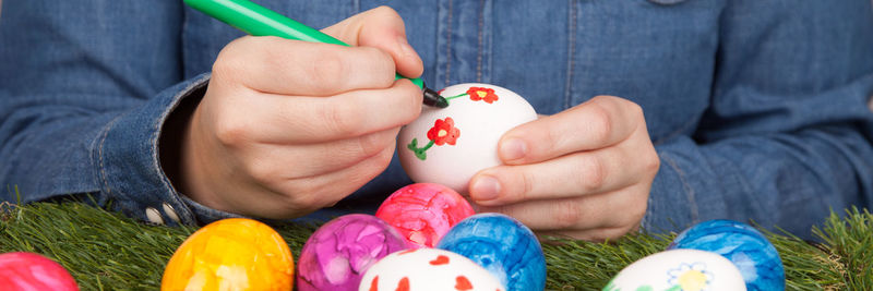 Midsection of woman decorating easter egg
