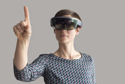 Woman wearing mixed reality smartglasses raising her hand