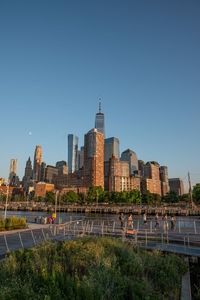 Buildings in city against clear blue sky