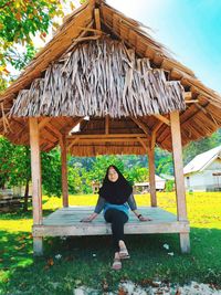 Full length portrait of woman standing against built structure