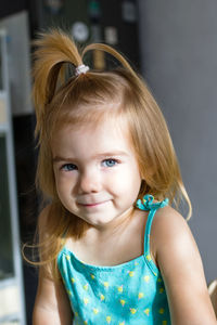 Adorable baby girl with blond hair and blue eyes in the morning in sunlight.