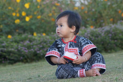 Cute boy sitting on field