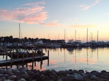 Sailboats in sea at sunset