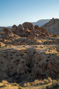 Scenic view of rocky arid landscape and distant mountains against sky