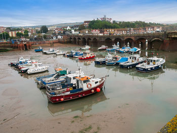 High angle view of boats moored at harbor in city