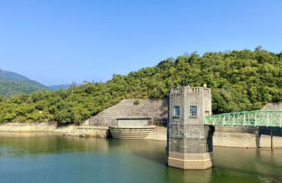 Built structure by lake against clear sky