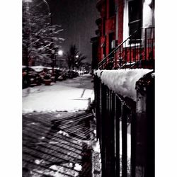 Snow covered buildings in city at night