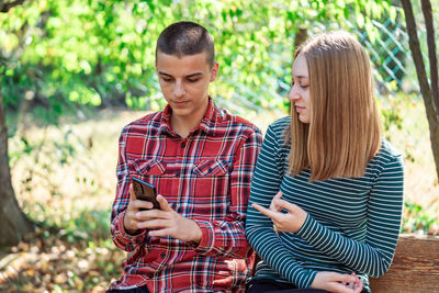 Portrait of smiling young woman using mobile phone