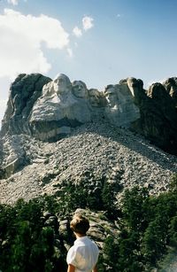 Rear view of woman standing against sculptured mountain