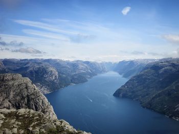 Scenic view of fjord amidst cliffs against sky