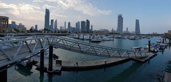 Panoramic view of city by river against sky