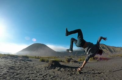 Person doing acrobatic stunt in landscape